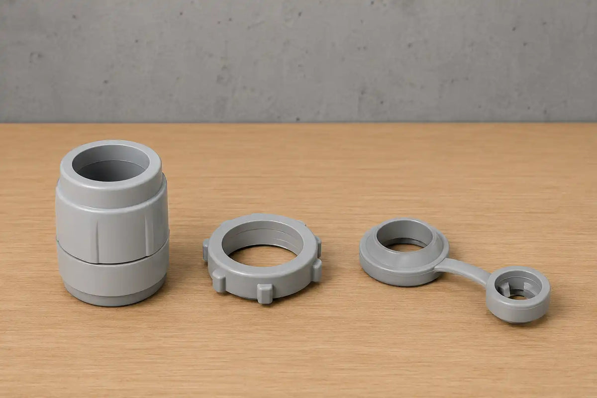 Accessoires de plomberie gris en plastique sur planche bois.